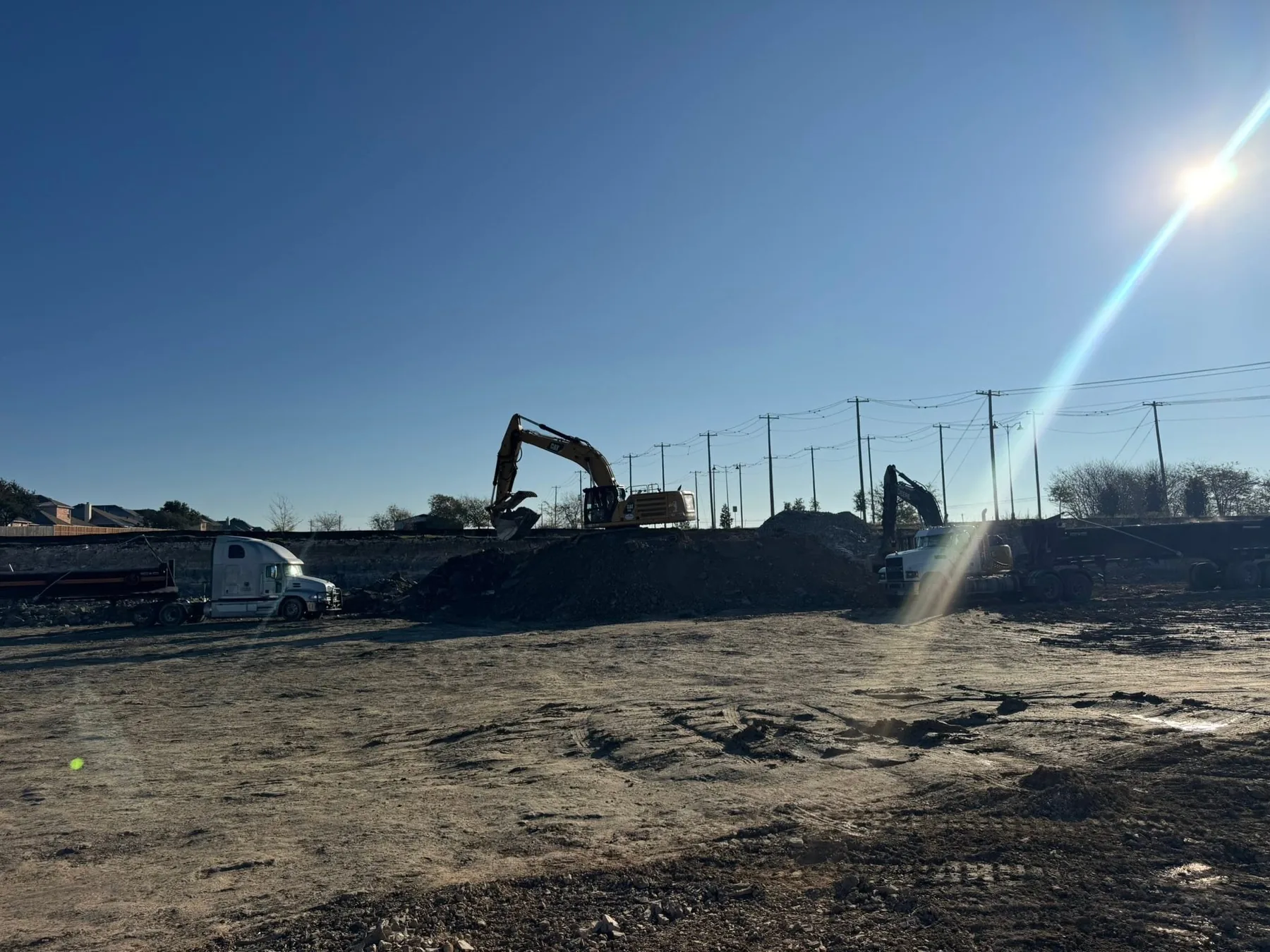 Two excavators and a haul truck working a cut lot