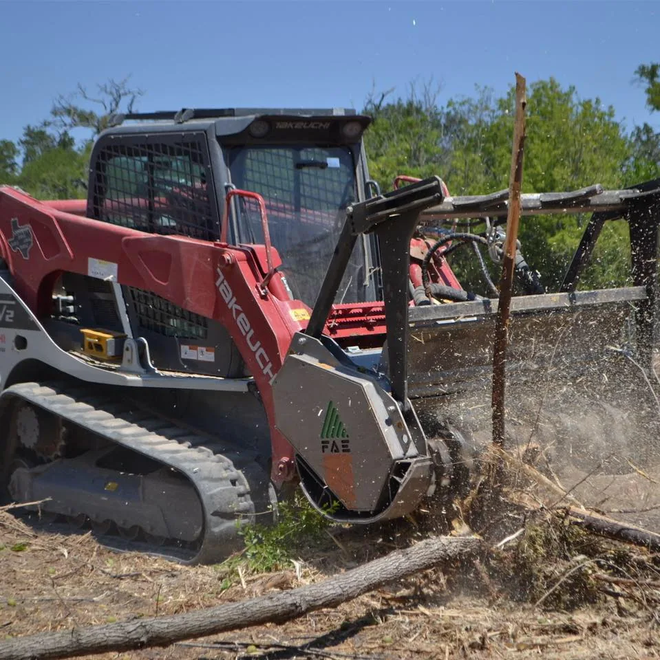A forestry mulching head cutting through brush, debris in the air